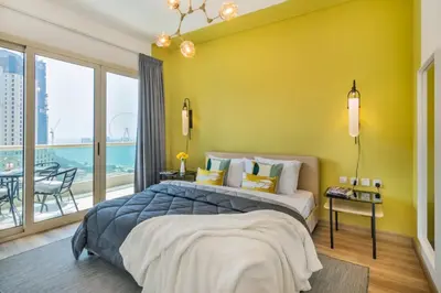 a bedroom with a large bed with a yellow wall at The Smart Concierge - Royal Oceanic in Dubai