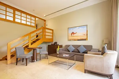 a living room with a couch and a staircase at Dubai Marine Beach Resort & Spa in Dubai