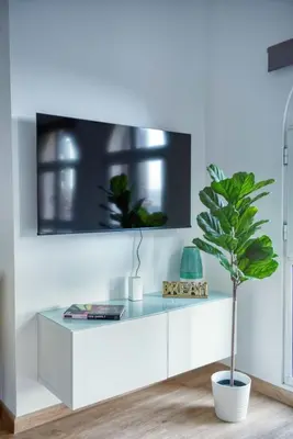 a white cabinet with a potted plant in a room at The Smart Concierge - Discovery Gardens street 4 in Dubai