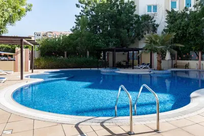 a large swimming pool with blue water at The Smart Concierge - Discovery Gardens street 4 in Dubai