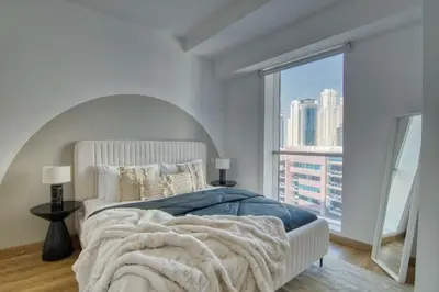 a bedroom with a large bed with a large window at The Smart Concierge - Damac Waves in Dubai