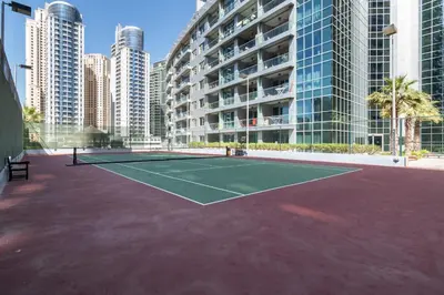 a tennis court in a city with tall buildings at The Smart Concierge - Damac Waves in Dubai