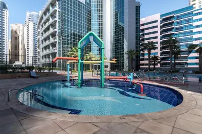 a pool with a water slide in a city at The Smart Concierge - Damac Waves in Dubai