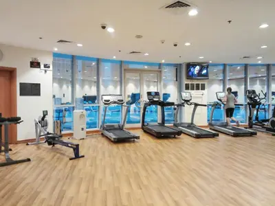 a woman in a gym with several tread machines at The Smart Concierge - Damac Waves in Dubai