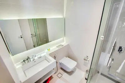 a bathroom with a sink and a toilet and a mirror at Stylish Studio in West Avenue Dubai Marina in Dubai
