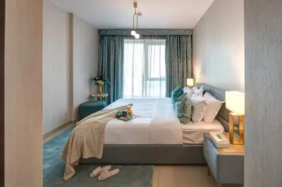 a bedroom with a large bed and a window at Durrani Homes - Designer 2BR Apt with stunning Burj khalifa and Fountain View in Dubai