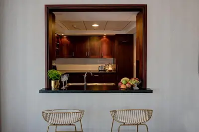 a kitchen with two chairs and a mirror at Durrani Homes - Designer 2BR Apt with stunning Burj khalifa and Fountain View in Dubai