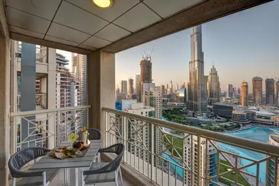 a balcony with a table and chairs and a view of the city at Durrani Homes - Designer 2BR Apt with stunning Burj khalifa and Fountain View in Dubai