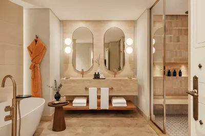 a bathroom with a tub and a sink and mirrors at Jumeirah Beach Hotel Dubai in Dubai