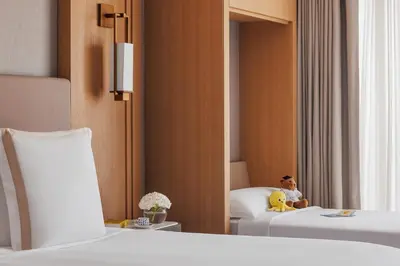 a little boy sitting on a bed in a hotel room at Jumeirah Beach Hotel Dubai in Dubai
