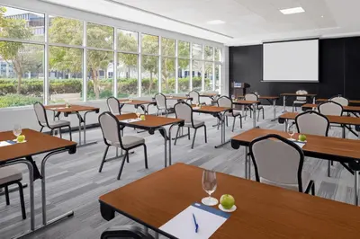 a classroom with tables and chairs and a projection screen at Holiday Inn Express Dubai Internet City by IHG in Dubai
