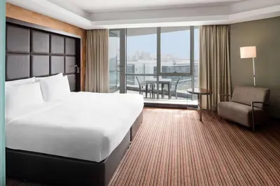 a hotel room with a large bed and a chair at Radisson Blu Hotel, Dubai Media City in Dubai