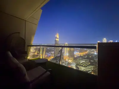 a room with a view of a city at night at FIRST CLASS 3BR with full BURJ KHALIFA and FOUNTAIN VIEW in Dubai