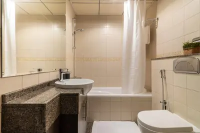 a bathroom with a sink and a toilet and a tub at The Smart Concierge - Bay Central in Dubai