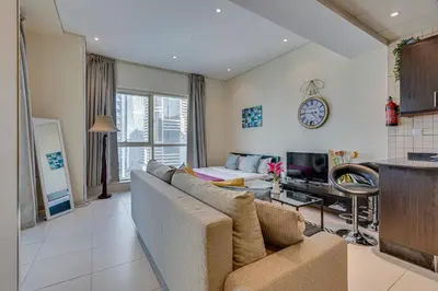 a living room with a couch and a tv at Sea View Studio 10min from beach Royal Oceanic in Dubai