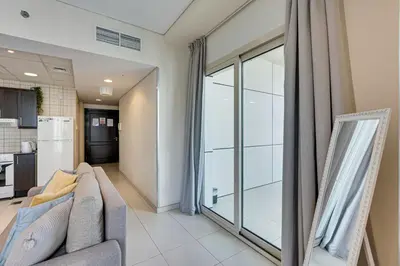 a living room with a couch and a large window at Sea View Studio 10min from beach Royal Oceanic in Dubai