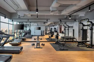 a gym with several treadmills and machines at DoubleTree by Hilton Dubai M Square Hotel & Residences in Dubai