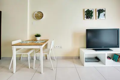a dining room with a table and a tv at Splendid Studio in Marina View Towers in Dubai