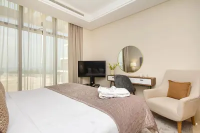 a bedroom with a bed and a chair and a mirror at Bespoke Holiday Homes - Palm Jumeirah- 2 Bedroom Sea View with Pool & Beach Access, The 8 in Dubai