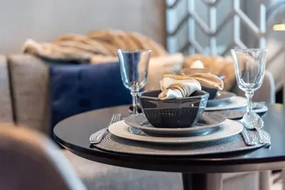 a table with two plates and wine glasses on it at The Smart Concierge - Damac Prive in Dubai