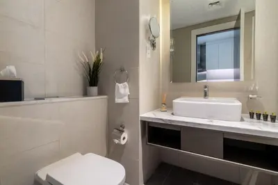 a bathroom with a sink and a toilet and a mirror at The Smart Concierge - Damac Prive in Dubai