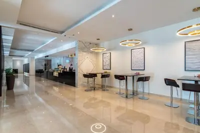 a lobby with stools and tables in a building at The Smart Concierge - Damac Prive in Dubai