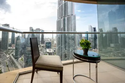 a table and a chair on a balcony with a view at Fashion Avenue Dubai Mall-Burj Khalifa by The SHH in Dubai