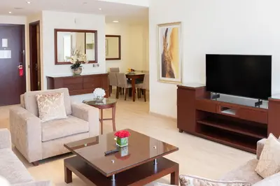 a living room with a couch and a tv at Grand Millennium Dubai in Dubai