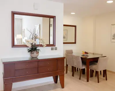 a dining room with a table and a mirror at Grand Millennium Dubai in Dubai