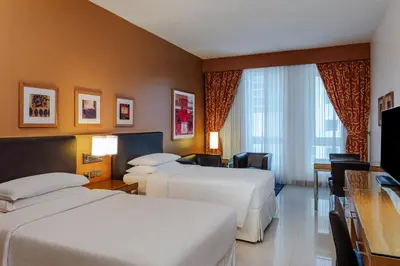 a hotel room with two beds and a television at Four Points by Sheraton Bur Dubai in Dubai