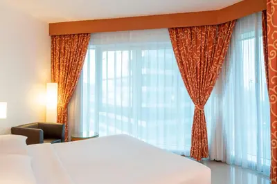 a bedroom with a bed and a large window at Four Points by Sheraton Bur Dubai in Dubai