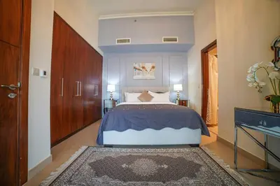 a bedroom with a large bed with a blue headboard at Modern 2BR with Balcony Sea Views and Pool, Gym Near Attractions in Dubai