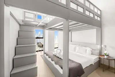 a bedroom with a loft bed with white walls at Modern 2BR with Balcony Sea Views and Pool, Gym Near Attractions in Dubai