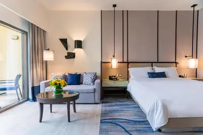 a hotel room with a bed and a couch at Amwaj Rotana, Jumeirah Beach - Dubai in Dubai