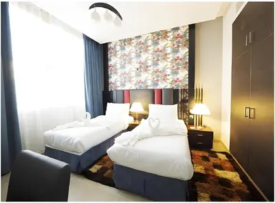 two beds in a hotel room with a large window at Skylark Hotel Apartments AL Barsha in Dubai