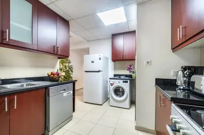 a kitchen with a refrigerator and a washer and dryer at The Smart Concierge - Bahar 1 in Dubai