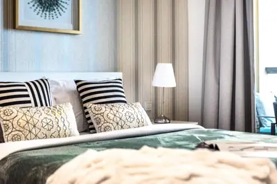 a bedroom with a bed with pillows and a lamp at The Smart Concierge - Bahar 1 in Dubai