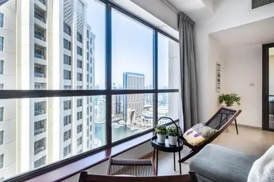 a room with a large window with a couch and chairs at The Smart Concierge - Bahar 1 in Dubai
