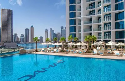a large swimming pool with chairs and umbrellas and a building at Luton Vacation Homes - Damac Maison Prive Studio, Canal View, Dubai - 16AB03 in Dubai