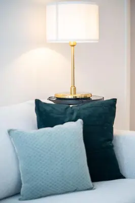 a lamp sitting on top of a couch with a pillow at HiGuests - Chic Apt with Balcony and Pool near Burj Khalifa in Dubai