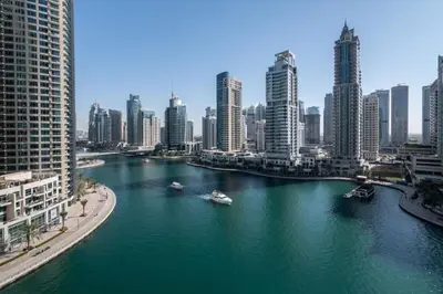 a river with boats in a city with tall buildings at GuestReady Holiday Homes - A Sigh of Bliss in Dubai