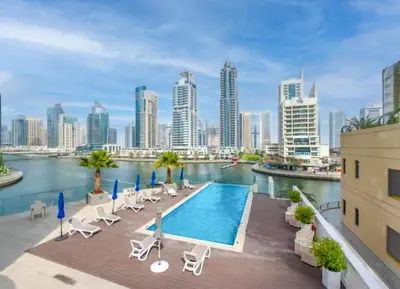 a swimming pool with chairs and a city skyline at GuestReady Holiday Homes - A Sigh of Bliss in Dubai