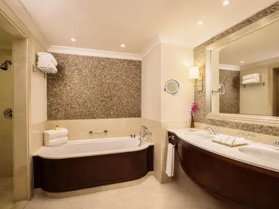 a bathroom with a large tub and a large mirror at JA Palm Tree Court, Dubai in Dubai