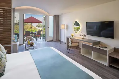 a hotel room with a bed and a desk and a television at JA Palm Tree Court, Dubai in Dubai