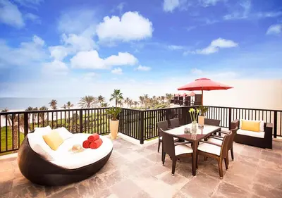 a patio with a table and chairs on a balcony at JA Palm Tree Court, Dubai in Dubai