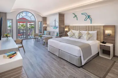 a bedroom with a large bed and a living room at JA Palm Tree Court, Dubai in Dubai