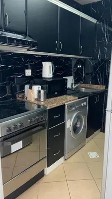 a kitchen with a stove and a washing machine at skynest homes studio in JLT in Dubai