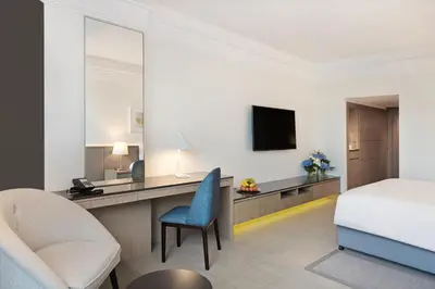 a hotel room with a bed and a desk and a chair at JA Beach Hotel, Dubai in Dubai