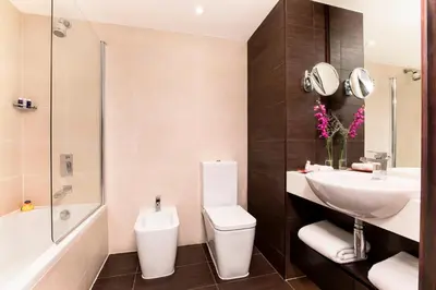 a bathroom with a sink and a toilet and a tub at JA Beach Hotel, Dubai in Dubai