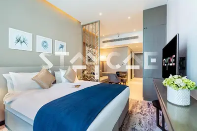 a hotel room with a large bed and a desk at Staycae Holiday Homes - Prive in Dubai